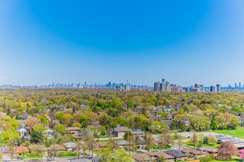 an aerial view of a neighborhood with a city skyline in the background